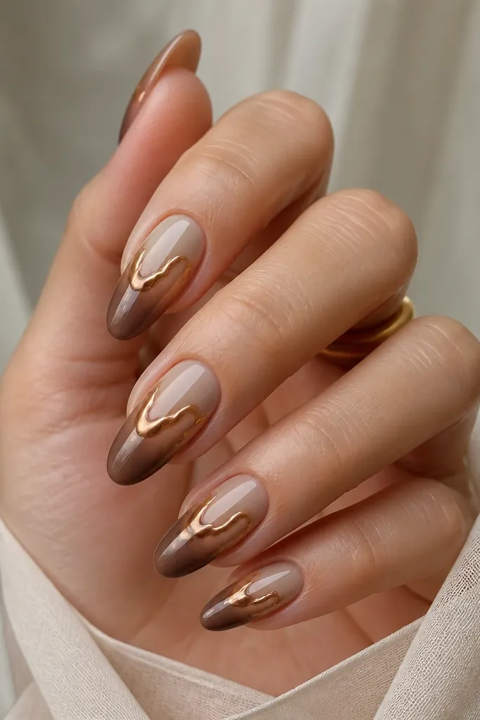 Medium almond nails with taupe beige at the cuticle fading into cocoa brown at the tips. Bronze chrome is melted into the upper half with a slightly uneven, liquid-metal effect.