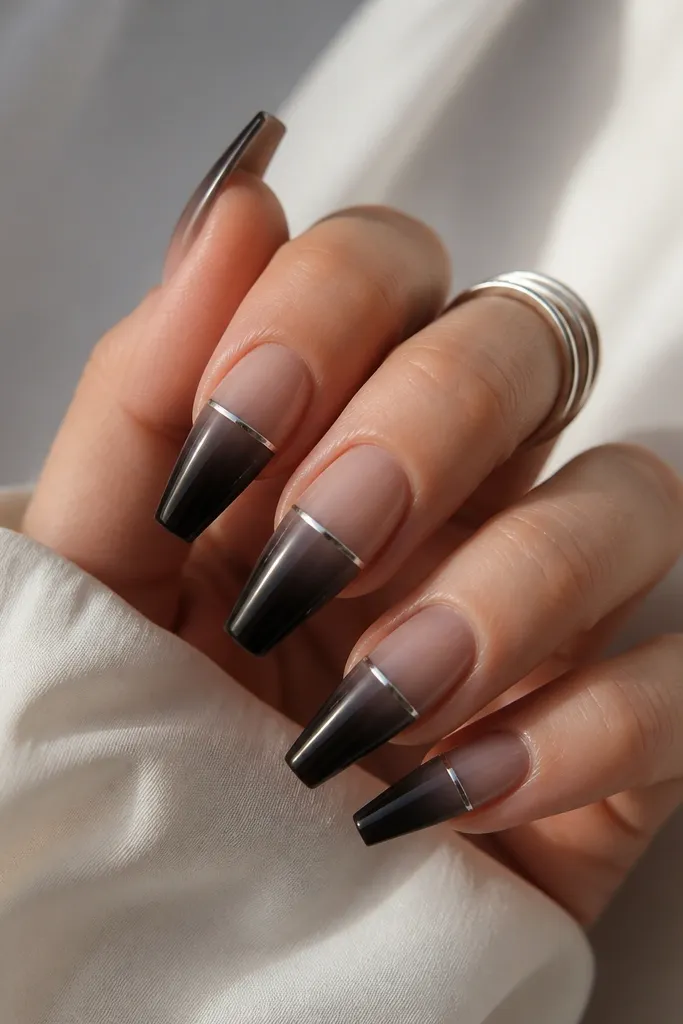 Coffin nails with cool nude at the cuticle blending into near-black at the tips. Platinum chrome is applied as a thin top edge across the upper third, like a razor line.