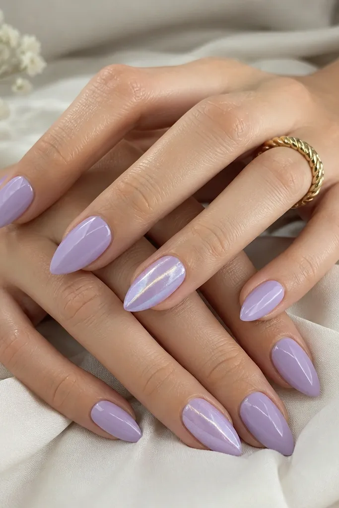 Short stiletto nails in lavender cream glossy polish. On one accent nail per hand, there's a single pearlized shimmer stripe running vertically down the center. The rest of the nails are smooth and glossy.